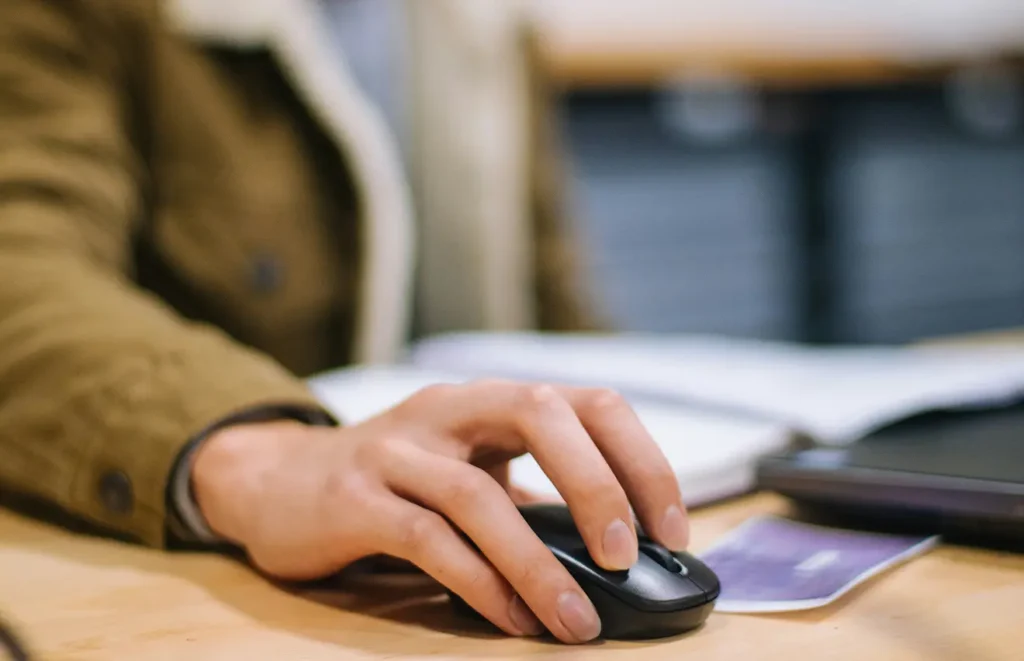 En närbild på en anonym människas hand som scrollar på en datormus.