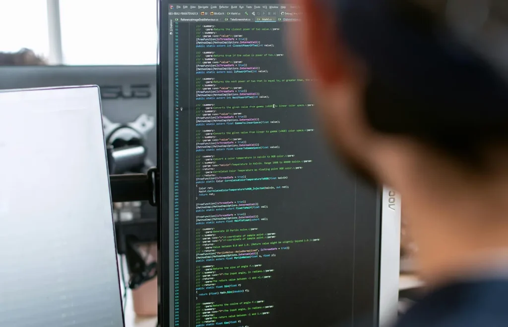 En bild tagen över axeln på en anonym utvecklare och analyserar sin kod på en datorskärm