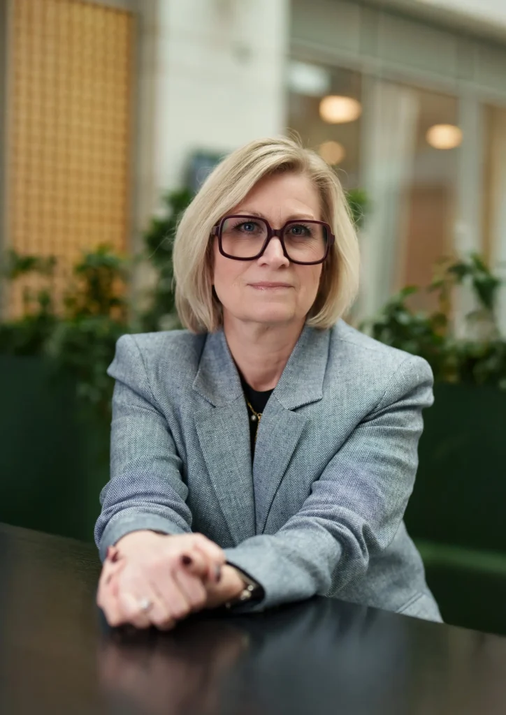 Ett personporträtt på en medelålders kvinna som tittar in i kameran.