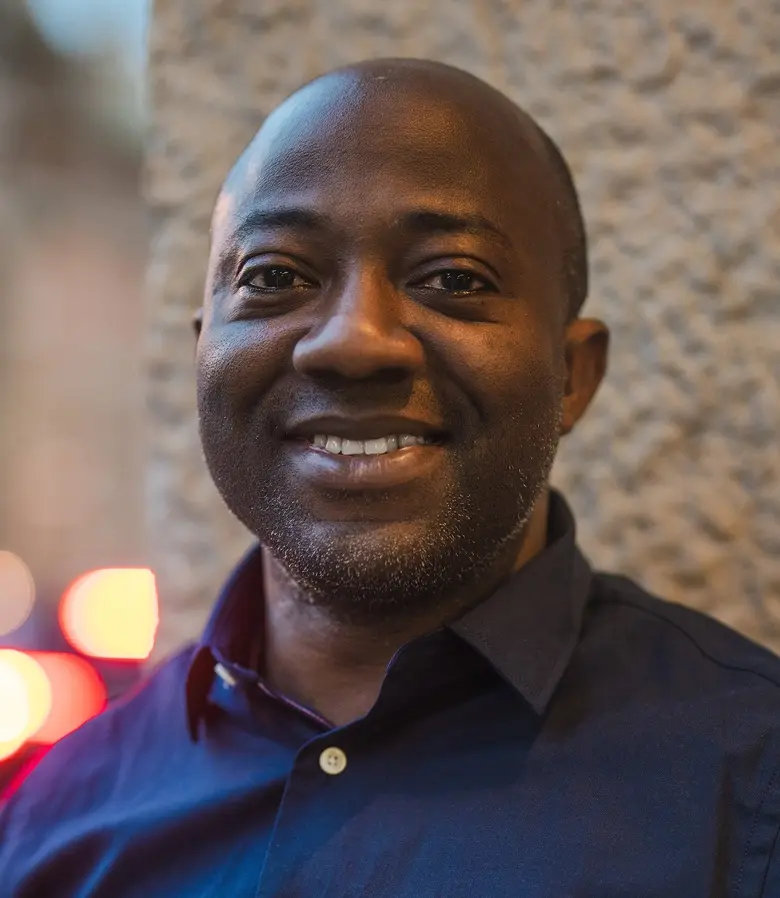 Ett personporträtt på en medelålders man som ler och tittar in i kameran.